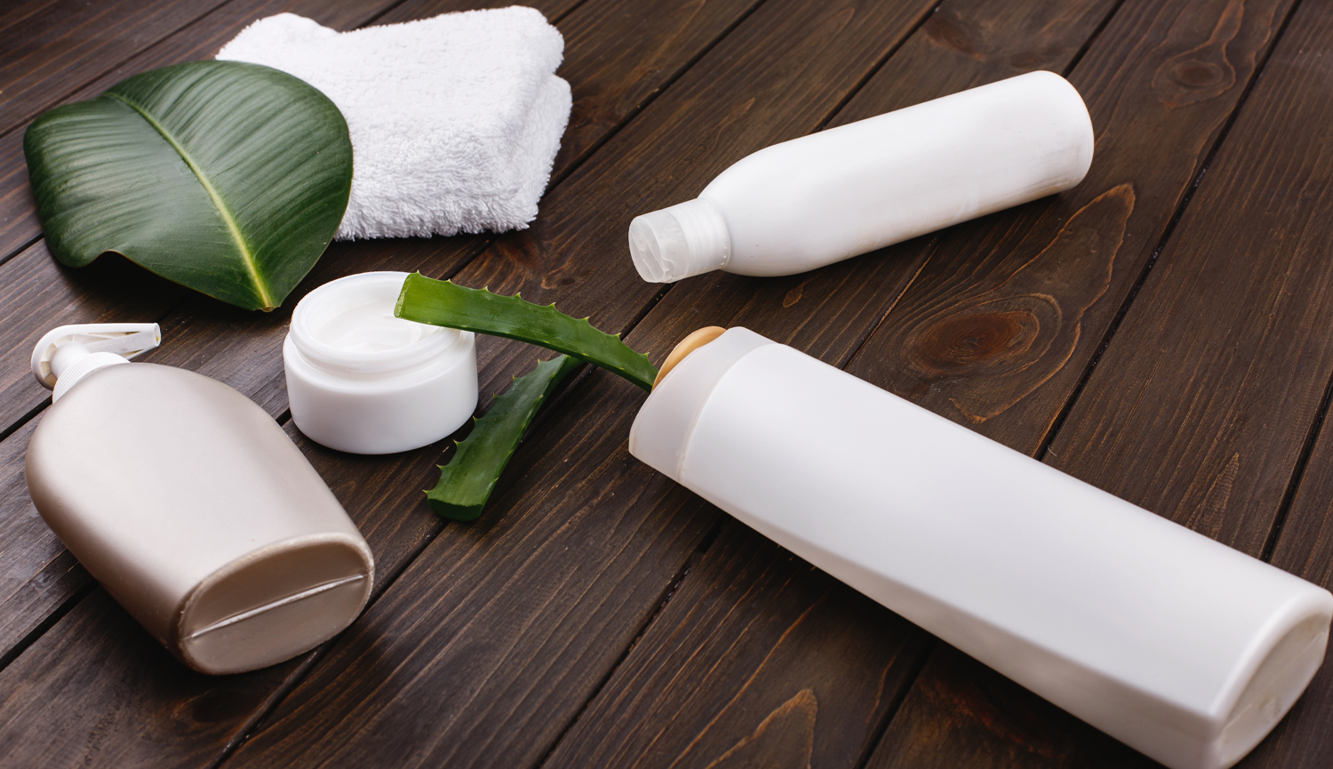 White Towel Bottles Shampoo Conditioner Lie Table With Green Leaf Aloe Blog Featured Image